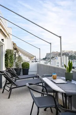 a balcony with tables and chairs on a roof at Nueva era @ Athens heart , Romvis apartments in Athens