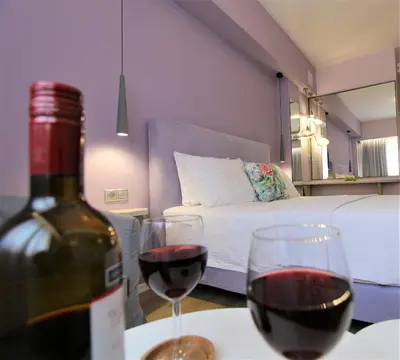 a bottle of wine sitting on a table with two glasses at Aiolos Apartments Ermou 64 Monastiraki Plaka Junior Suite in Athens