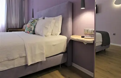 a bedroom with a bed and a side table at Aiolos Apartments Ermou 64 Monastiraki Plaka Junior Suite in Athens