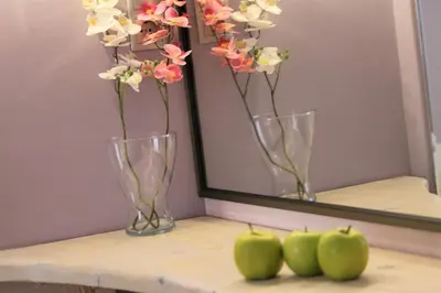 two vases with flowers and three green apples on a shelf at Aiolos Apartments Ermou 64 Monastiraki Plaka Junior Suite in Athens