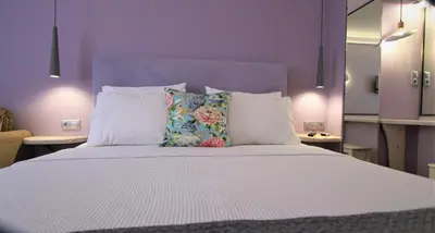 a bedroom with a large bed with white sheets and pillows at Aiolos Apartments Ermou 64 Monastiraki Plaka Junior Suite in Athens