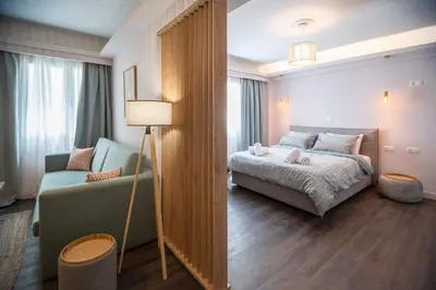 a bedroom with a bed and a couch and a lamp at Niki Athens Suites - Cosy Suite in Monastiraki Historical Centre in Athens