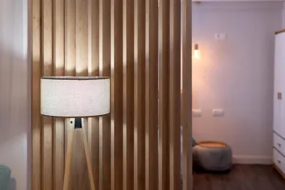 a lamp in a room with a wooden wall at Niki Athens Suites - Cosy Suite in Monastiraki Historical Centre in Athens