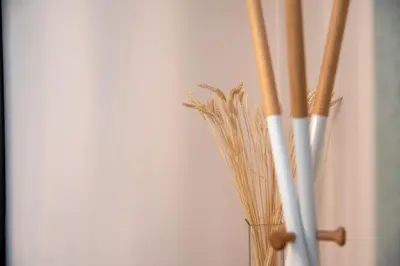 a vase filled with bamboo sticks next to a wall at Niki Athens Suites - Cosy Suite in Monastiraki Historical Centre in Athens