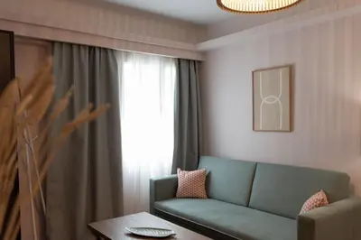 a living room with a green couch and a window at Niki Athens Suites - Cosy Suite in Monastiraki Historical Centre in Athens
