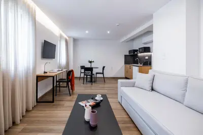 a living room with a white couch and a table at Pnoe Urban Living in Athens