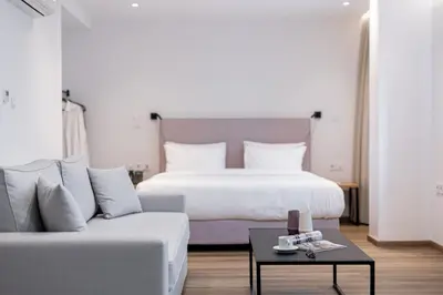 a bedroom with a bed and a couch and a table at Pnoe Urban Living in Athens