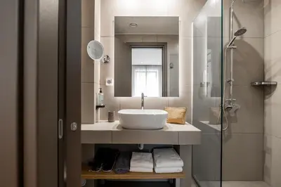 a bathroom with a sink and a shower at Pnoe Urban Living in Athens
