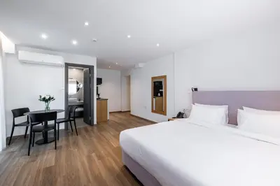 a hotel room with a bed and a desk and a table at Pnoe Urban Living in Athens