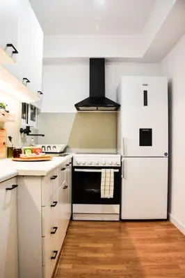 a kitchen with white cabinets and a white refrigerator at Newly renovated-City Center Apartment in Athens