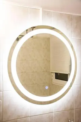 a round mirror on a wall in a bathroom at Newly renovated-City Center Apartment in Athens