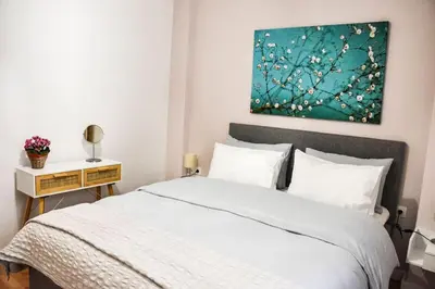 a bedroom with a bed and a painting on the wall at Newly renovated-City Center Apartment in Athens