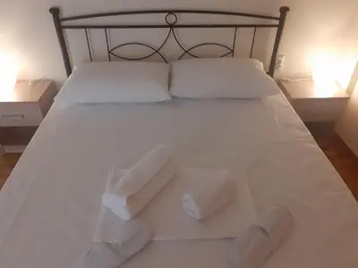 a bed with two pillows and two towels on it at A Apartments in Athens
