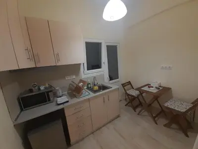 a kitchen with a counter and a table and chairs at A Apartments in Athens