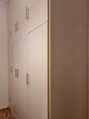 a row of white cabinets in a room at A Apartments in Athens