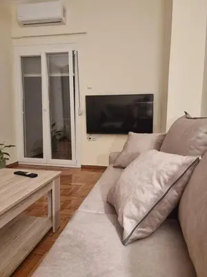 a living room with a couch and a flat screen tv at A Apartments in Athens