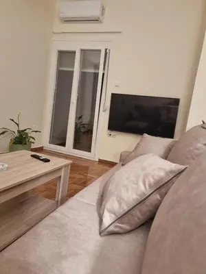 a living room with a couch and a television at A Apartments in Athens