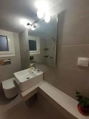 a bathroom with a sink and a toilet and a mirror at A Apartments in Athens