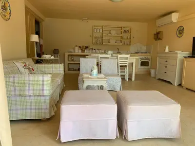 a living room with two stools and a kitchen at Endless Seaview in Porto Rafti