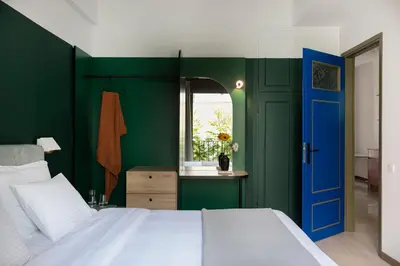 a bedroom with green walls and a blue door at Nileos House in Athens