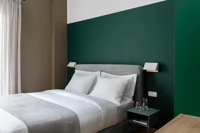 a bedroom with a large bed with a green wall at Nileos House in Athens