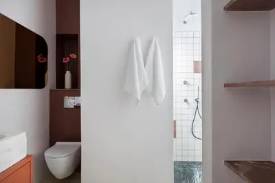 a white bathroom with a toilet and a shower at Nileos House in Athens