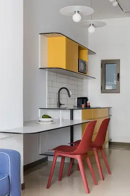 a kitchen with two red chairs and a counter at Nileos House in Athens