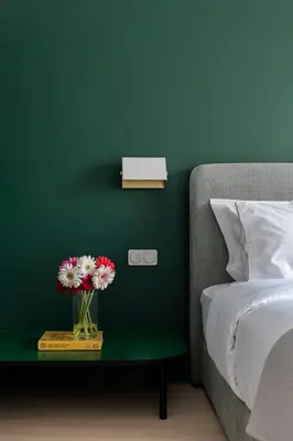a vase of flowers on a table next to a bed at Nileos House in Athens