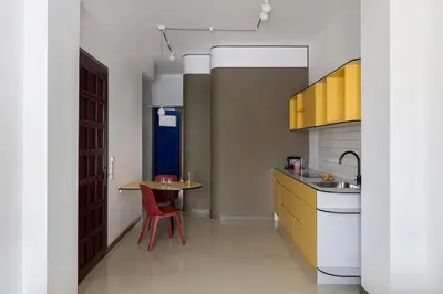 a kitchen with yellow cabinets and a table and a sink at Nileos House in Athens