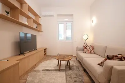 a living room with a couch and a tv at The Downtown Oasis [4' To Panormou Metro Station] in Athens