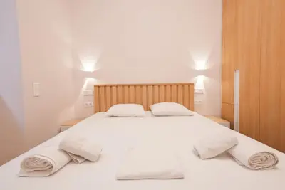 a bedroom with a white bed with towels on it at The Downtown Oasis [4' To Panormou Metro Station] in Athens