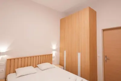 a bedroom with a white bed and a wooden cabinet at The Downtown Oasis [4' To Panormou Metro Station] in Athens