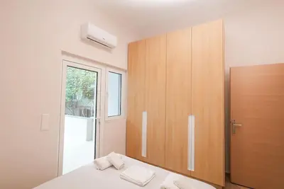 a bedroom with a bed and a wooden cabinet at The Downtown Oasis [4' To Panormou Metro Station] in Athens