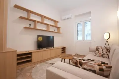 a living room with a flat screen tv and a couch at The Downtown Oasis [4' To Panormou Metro Station] in Athens