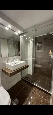 a bathroom with a sink and a glass shower at HP Studio Luxury Apartment in Athens