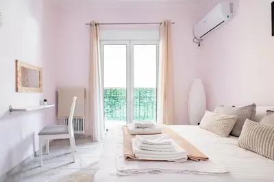 a white room with a bed and a chair at Your Perfect Place 1min from Kato Patissia Station -100Mbps in Athens
