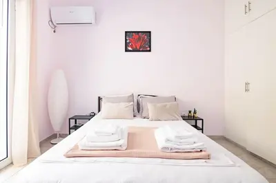 a white bedroom with a bed with towels on it at Your Perfect Place 1min from Kato Patissia Station -100Mbps in Athens