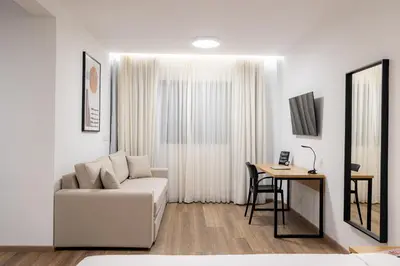 a white living room with a couch and a table at Earos Urban Living in Athens