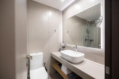 a bathroom with a sink and a toilet and a mirror at Earos Urban Living in Athens