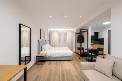 a bedroom with a bed and a living room at Earos Urban Living in Athens
