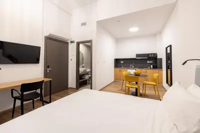 a hotel room with a bed and a kitchen at Earos Urban Living in Athens