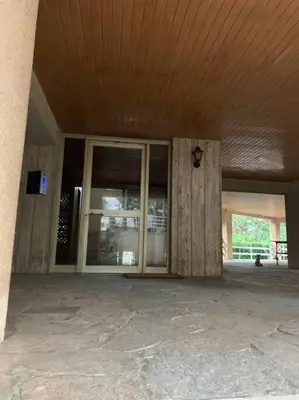an empty building with a wooden ceiling and glass doors at Varkiza Lux Apartment in Varkiza