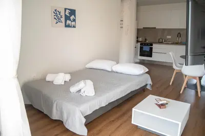 a white bedroom with a bed with towels on it at Naiads Nest - The Comfort Lux in Varkiza