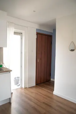 an empty living room with a wooden door at Naiads Nest - The Comfort Lux in Varkiza