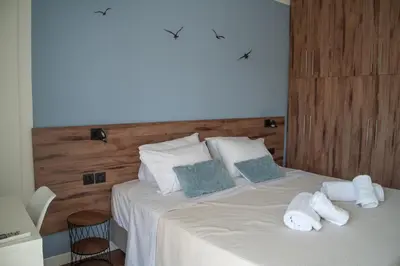 a bedroom with a bed with towels on it at Naiads Nest - The Comfort Lux in Varkiza