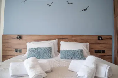 a bedroom with a bed with white towels on it at Naiads Nest - The Comfort Lux in Varkiza