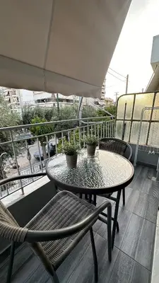 a patio table and chairs on a balcony at Kris boy in Athens