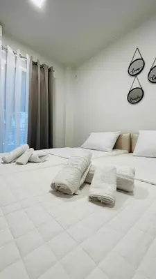 a white room with two beds with pillows on them at Kris boy in Athens