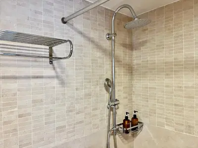 a shower with bottles on a shelf in a bathroom at Monastiraki Loft AthensApart in Athens
