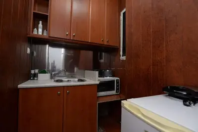 a kitchen with wooden cabinets and a sink and a microwave at Penthouse in the Heart of Athens in Athens